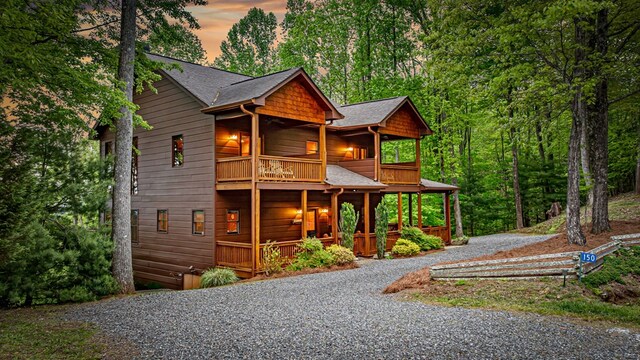view of front of home with a porch, driveway, and a balcony