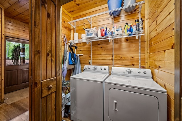 washroom featuring wooden walls, laundry area, separate washer and dryer, wooden ceiling, and wood finished floors