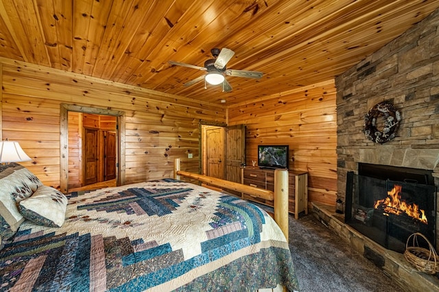 carpeted bedroom with wood ceiling, a fireplace, a ceiling fan, and wood walls