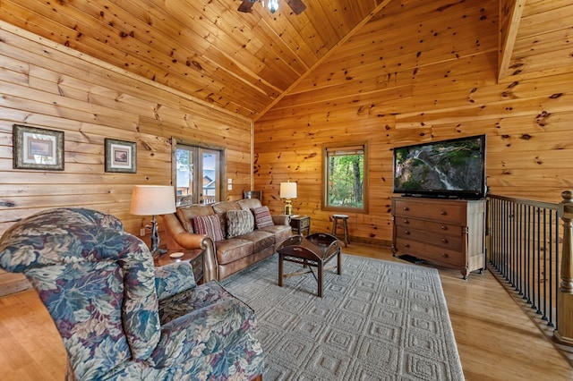 living area with light wood-style floors, a ceiling fan, wooden ceiling, lofted ceiling, and wooden walls