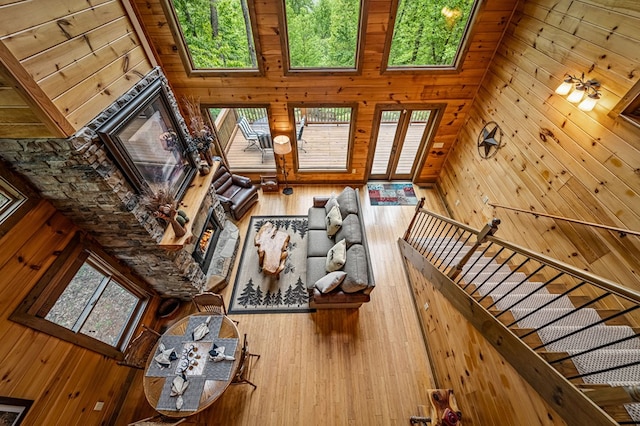 unfurnished living room featuring a lit fireplace, wood walls, and wood finished floors