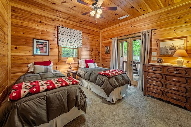 carpeted bedroom with visible vents, wooden walls, access to outside, wooden ceiling, and a ceiling fan