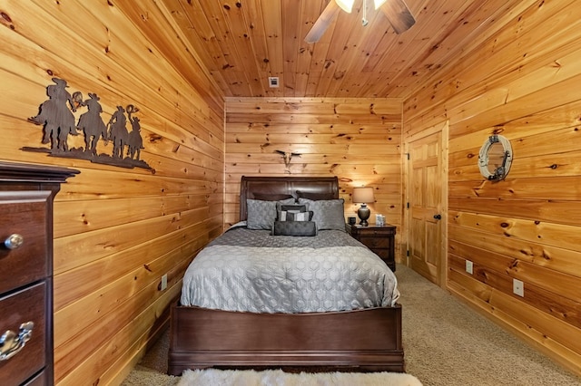 carpeted bedroom with a ceiling fan, wood ceiling, and wooden walls
