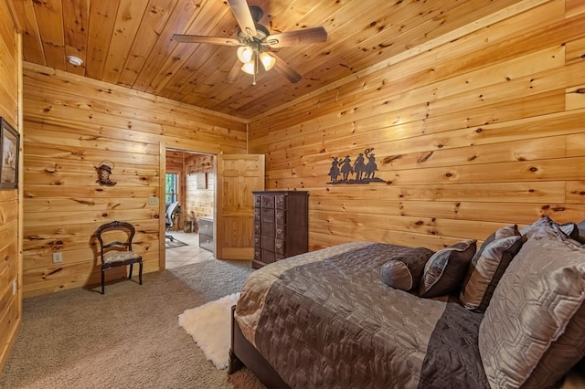 carpeted bedroom with ensuite bathroom, wood walls, wood ceiling, and ceiling fan
