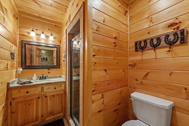 bathroom with toilet, wood walls, and vanity