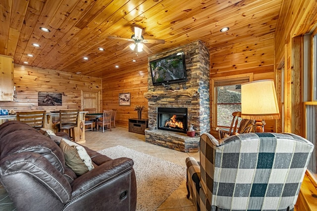 living area featuring wooden walls, a stone fireplace, tile patterned flooring, and wooden ceiling