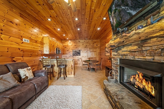 living area with ceiling fan, light tile patterned floors, wooden ceiling, wooden walls, and recessed lighting
