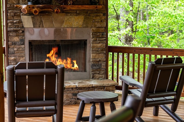 wooden terrace featuring a stone fireplace