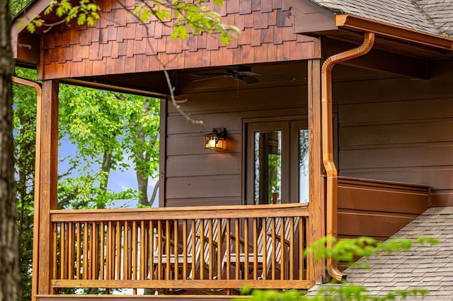 exterior space featuring a shingled roof and ceiling fan