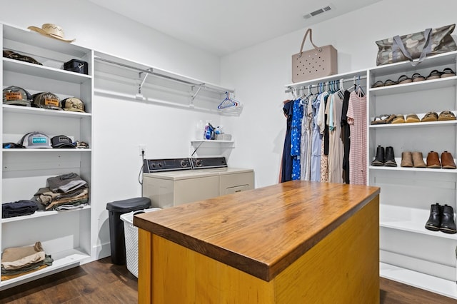 walk in closet with dark hardwood / wood-style flooring and washer and clothes dryer