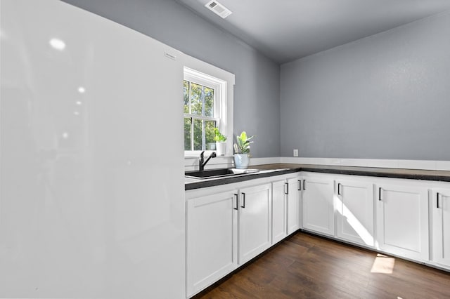 kitchen with white cabinetry, sink, and dark wood-type flooring