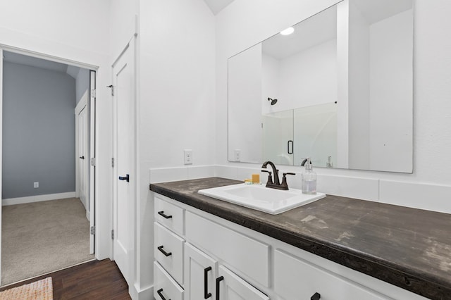 bathroom featuring vanity, hardwood / wood-style flooring, and a shower with shower door