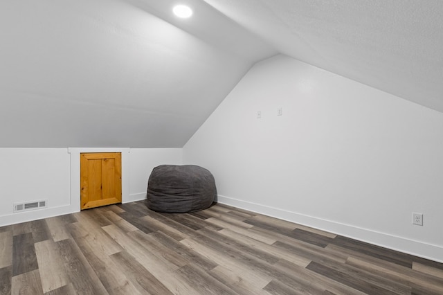 bonus room with hardwood / wood-style flooring, a textured ceiling, and lofted ceiling