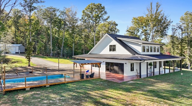 back of house featuring a patio area and a lawn