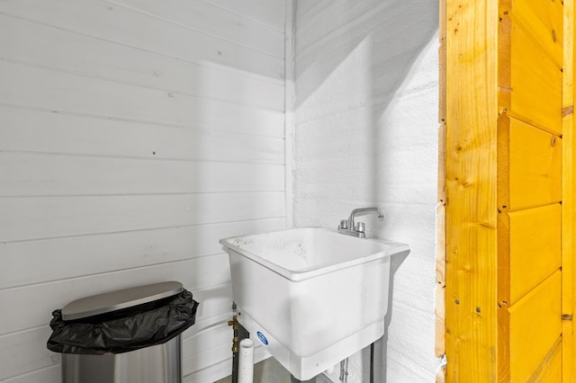 bathroom with wood walls and sink