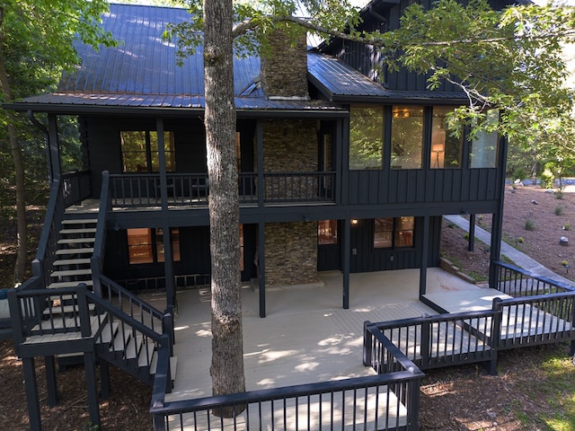 365 Browns Cove Rd, Blue Ridge, GA 30513 - rear view of house with stairway, stone siding, board and batten siding, metal roof, and a sunroom