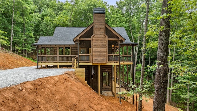 view of jungle gym with a forest view and a wooden deck