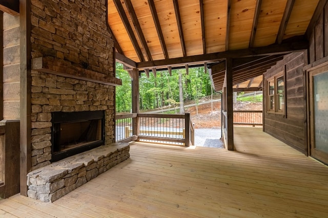 wooden deck with an outdoor stone fireplace