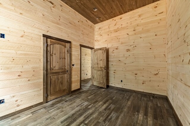 unfurnished room featuring wooden walls, wood ceiling, and dark wood finished floors