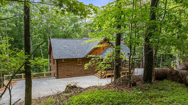 view of home's exterior featuring roof with shingles and fence