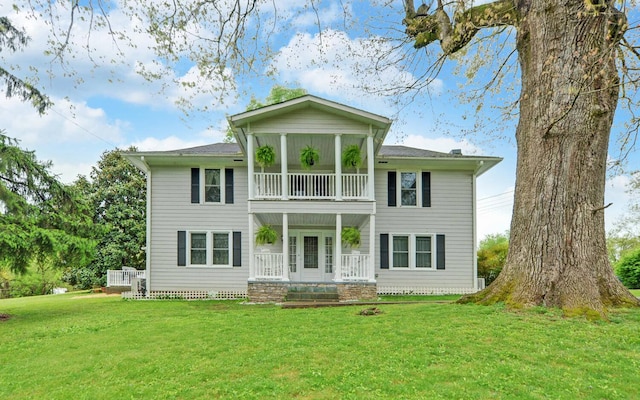 rear view of property with a yard and a porch