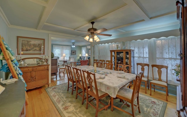 dining area featuring coffered ceiling, ceiling fan, crown molding, and light hardwood / wood-style flooring