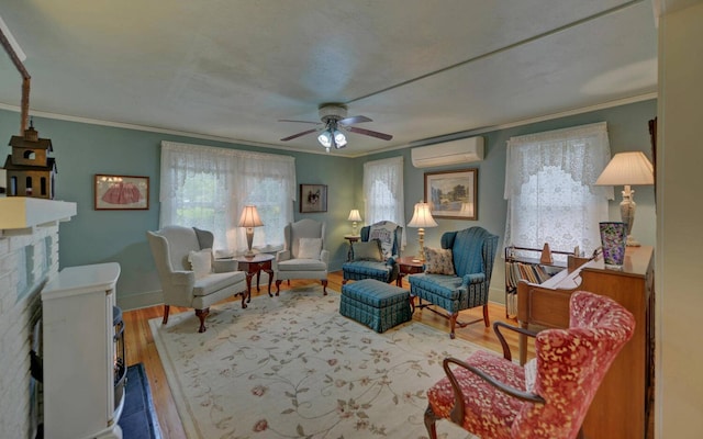 living area featuring a wall unit AC, ceiling fan, hardwood / wood-style floors, and ornamental molding