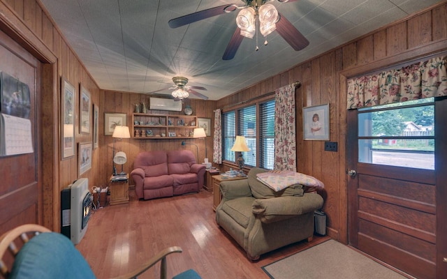 living room with light hardwood / wood-style floors, wooden walls, and a wall mounted AC