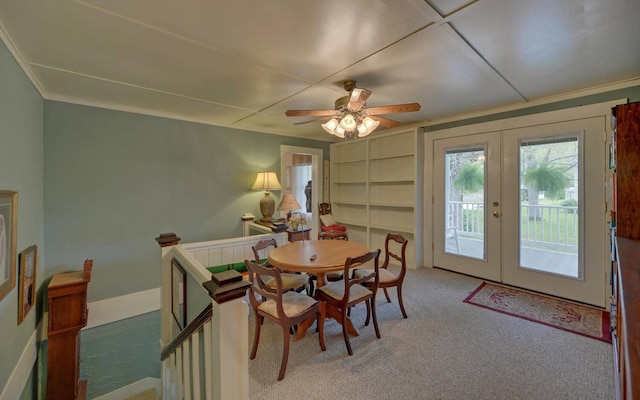 carpeted dining space featuring french doors, ceiling fan, and ornamental molding