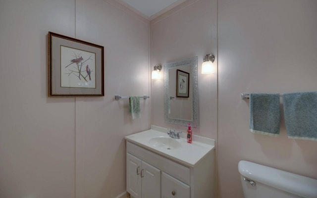 bathroom featuring vanity, toilet, and crown molding