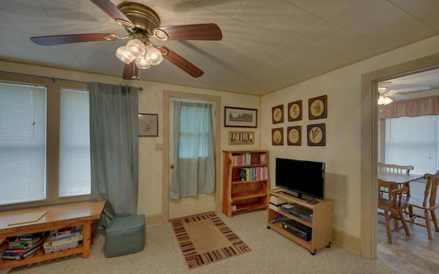 carpeted living room with ceiling fan