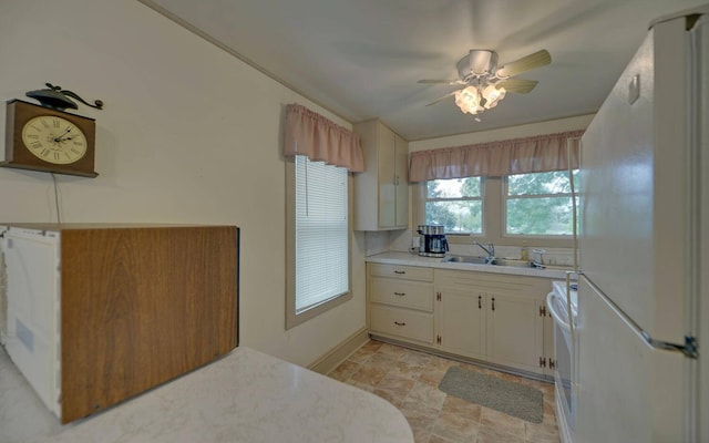 kitchen featuring ceiling fan, white fridge, range, and sink