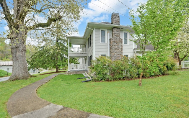 view of property exterior with a lawn, a balcony, and covered porch