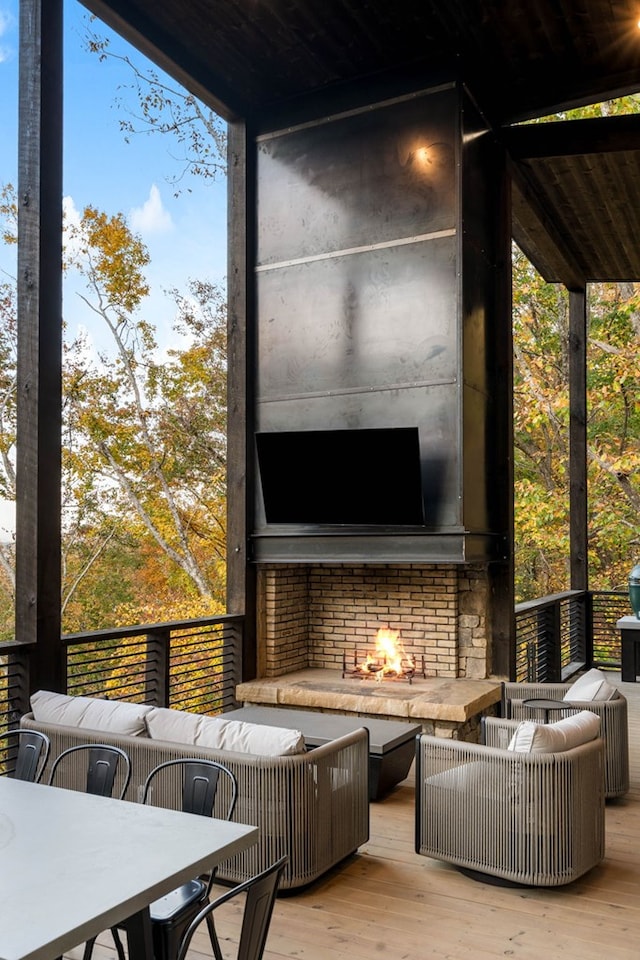 wooden deck with outdoor dining area and an outdoor living space with a fireplace