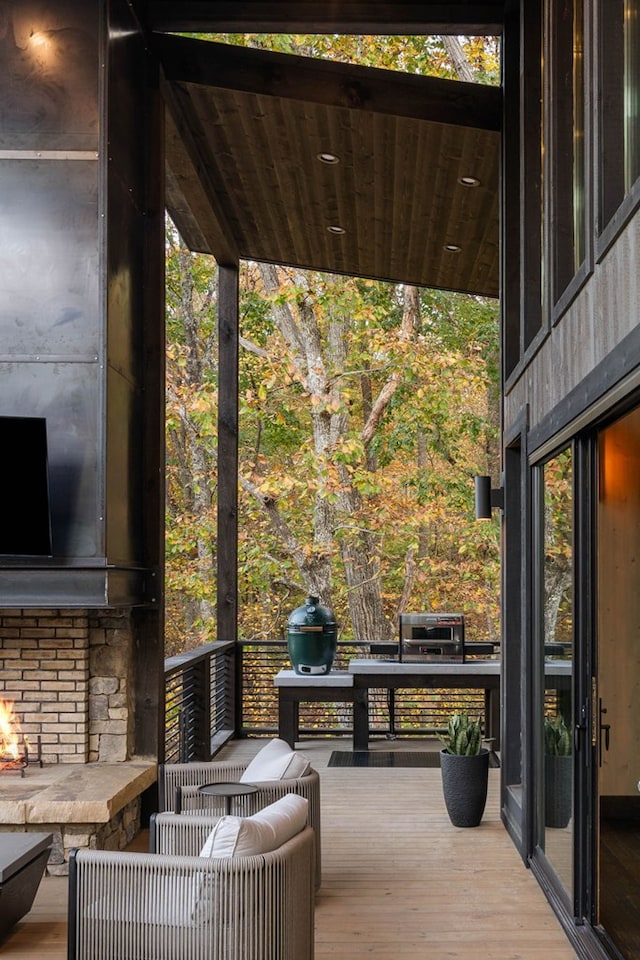 wooden terrace featuring an outdoor stone fireplace