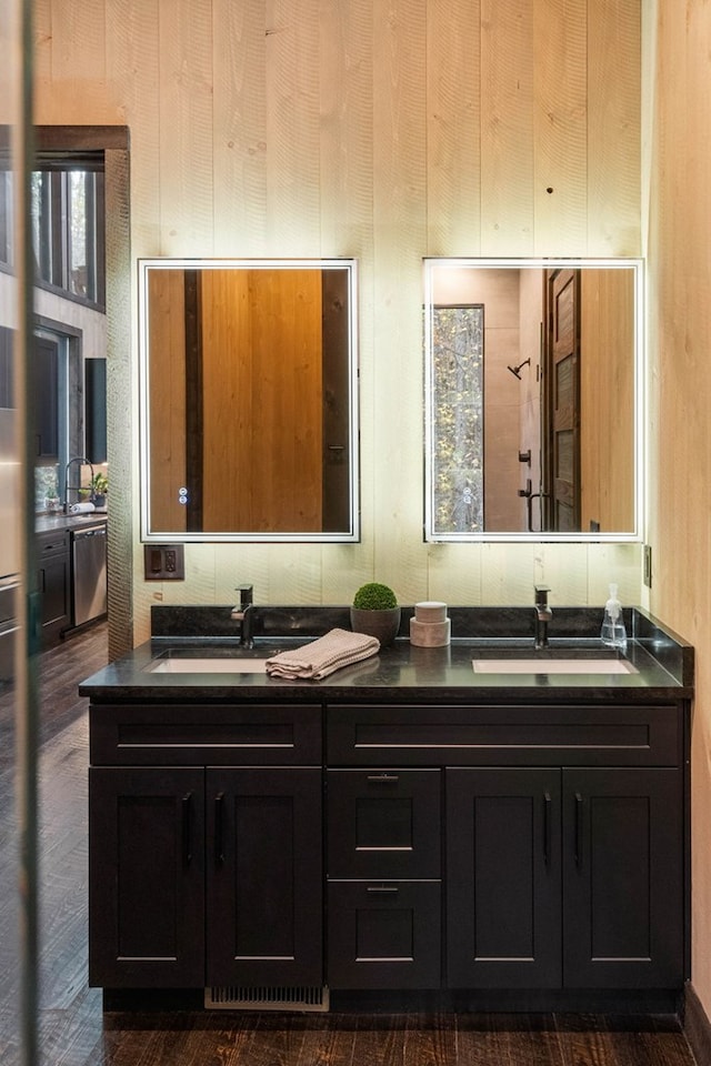 full bathroom with double vanity, a sink, and wood finished floors