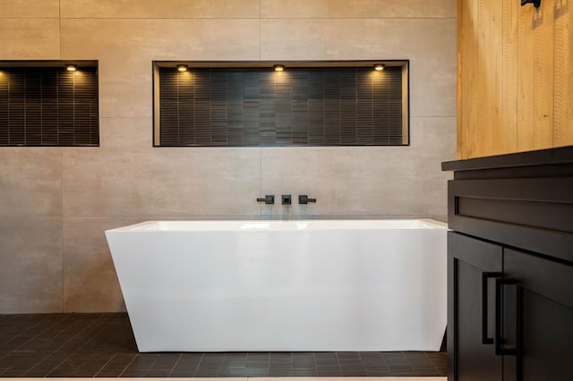 full bathroom with tile walls and a freestanding tub