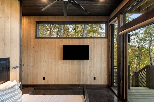 interior space with wood ceiling, wooden walls, and ceiling fan