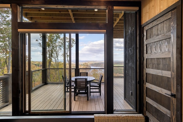 entryway featuring a wealth of natural light, beam ceiling, and wood-type flooring