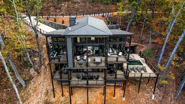 rear view of property with an outdoor pool