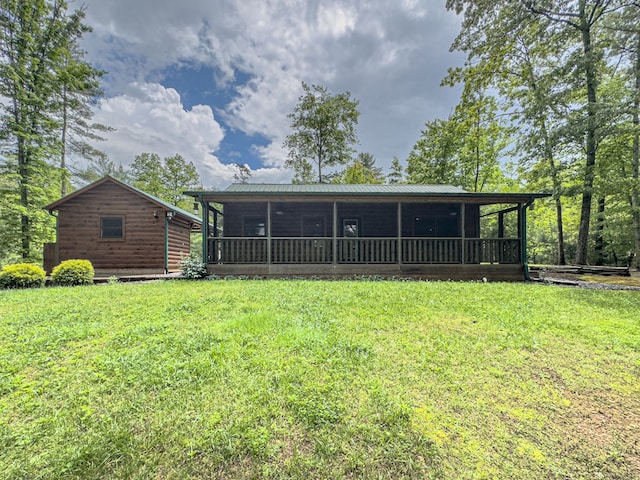 rear view of property featuring a sunroom and a yard