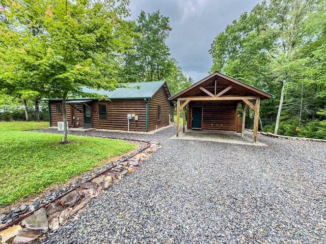 view of front facade featuring faux log siding, driveway, a front yard, and metal roof
