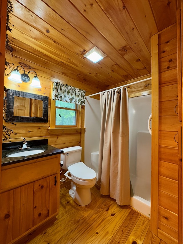 bathroom with wood finished floors, a stall shower, toilet, wood ceiling, and vanity