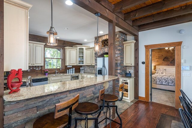 kitchen with hardwood / wood-style floors, light stone countertops, and decorative light fixtures