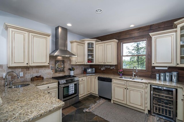 kitchen featuring wall chimney range hood, wine cooler, stainless steel appliances, and sink