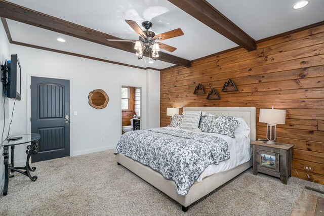 bedroom featuring wooden walls, beamed ceiling, carpet flooring, and ceiling fan