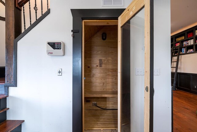 view of sauna / steam room with wood-type flooring and wood walls