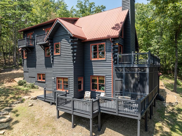 1363 NE Foxhound Trl, Ranger, GA 30734 - back of property featuring a chimney, a balcony, metal roof, and a deck