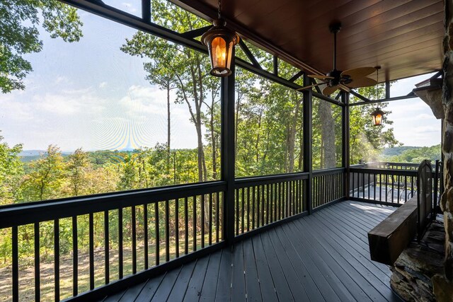 unfurnished sunroom with wood ceiling and ceiling fan