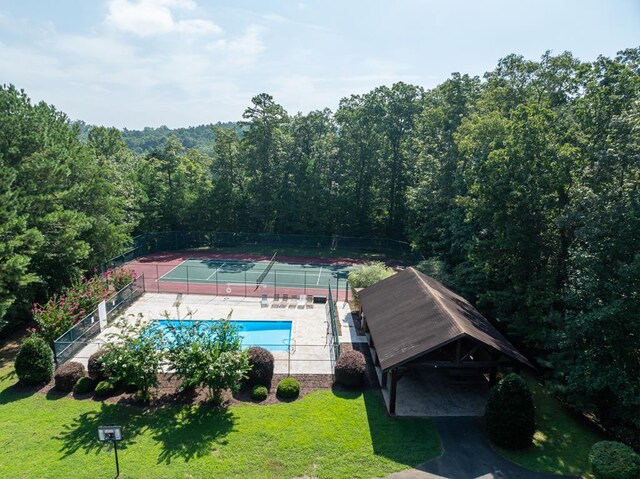 view of tennis court with a lawn